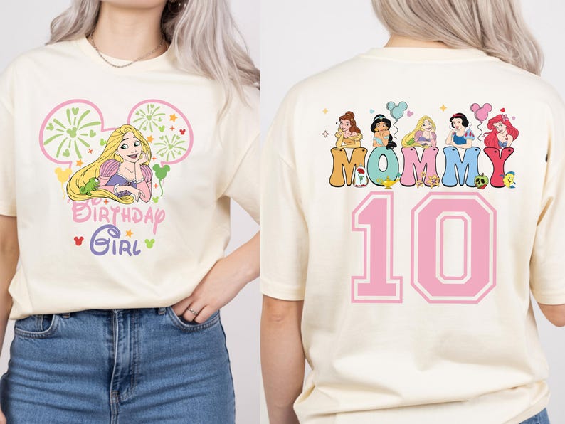 Puede incluir: Camiseta color crema con un gr&aacute;fico de Rapunzel y el texto "Birthday Girl" en la parte delantera. La parte trasera de la camiseta muestra la palabra "Mommy" con ilustraciones de princesas y el n&uacute;mero "10" en rosa.
