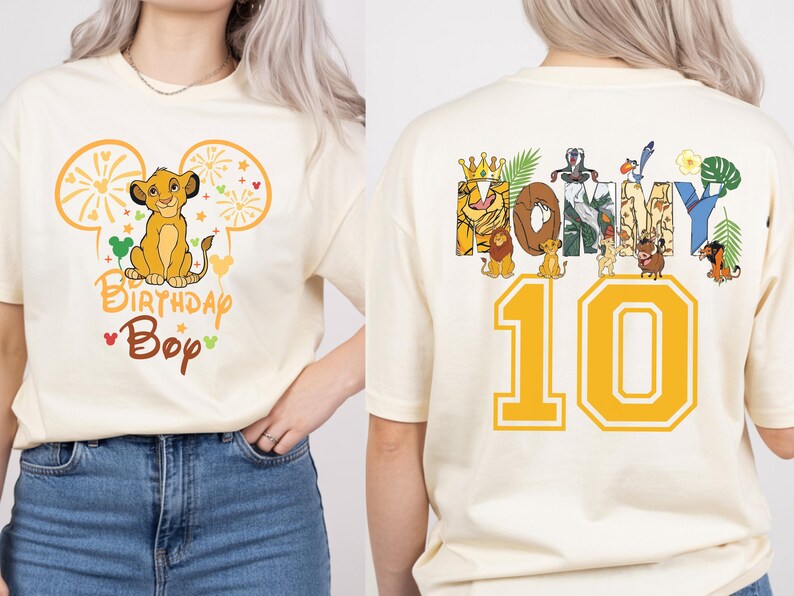 Puede incluir: Camiseta color crema con un dise&ntilde;o de Simba, orejas de Mickey Mouse y el texto "Birthday Boy". La parte trasera muestra "HONEY" con personajes de El Rey Le&oacute;n y el n&uacute;mero "10" en amarillo. Un dise&ntilde;o divertido y tem&aacute;tico.