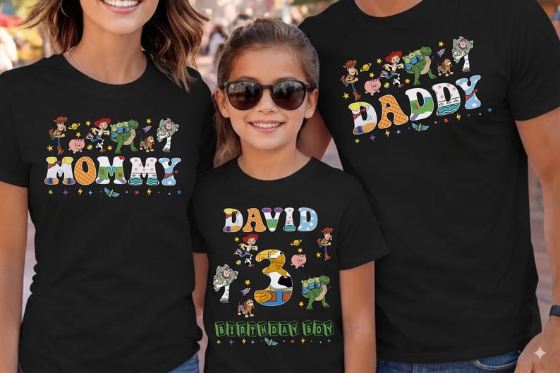 May include: Black t-shirts with colorful graphics featuring characters and text from the movie Toy Story. The shirts say "Mommy", "Daddy", and "David 3 Birthday Boy". The shirts are for a family.