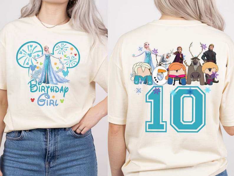 Puede incluir: Camiseta color crema con un gr&aacute;fico frontal de Elsa de Frozen y el texto "Birthday Girl". La parte trasera de la camiseta muestra el n&uacute;mero "10" y otros personajes de Frozen. El dise&ntilde;o es en tonos de azul, turquesa y blanco.