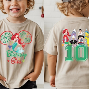 Puede incluir: Camiseta beige de manga corta con un gr&aacute;fico colorido de Ariel la sirenita, fuegos artificiales y el texto "Birthday Girl". La parte trasera de la camiseta muestra el n&uacute;mero "10" y otros personajes de la pel&iacute;cula La Sirenita.