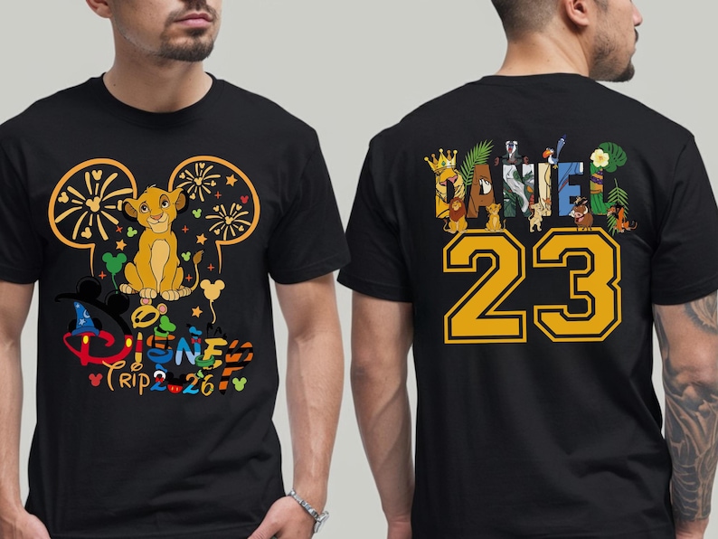 May include: Black t-shirt featuring a Simba graphic with the text "Disney Trip 2-26" on the front. The back of the shirt displays the name "Daniel" with the number "23" in yellow. The design incorporates Disney characters.