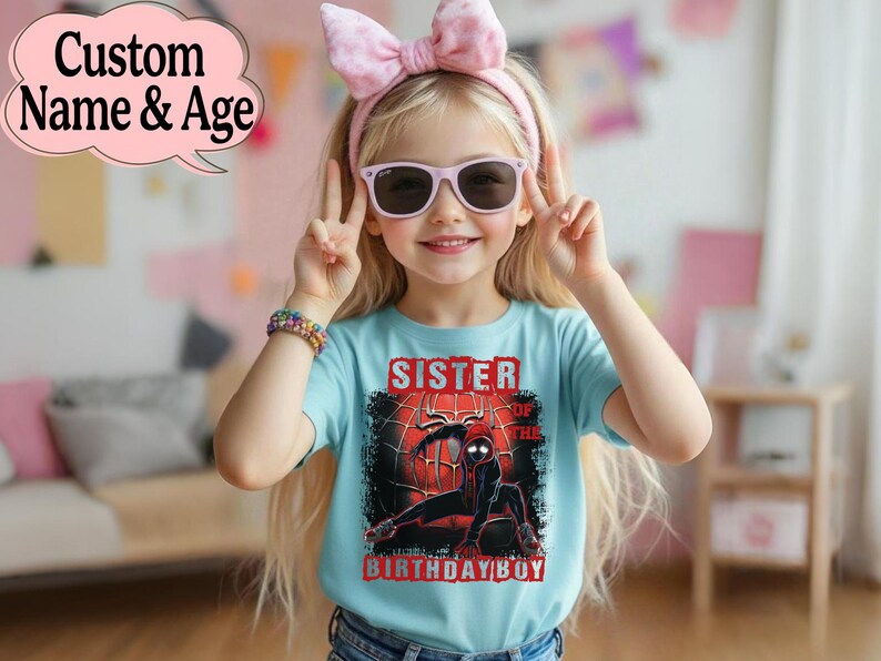 Puede incluir: Una ni&ntilde;a peque&ntilde;a lleva una camiseta azul claro con un gr&aacute;fico de Spider-Man y el texto "Sister of the Birthday Boy". Lleva gafas de sol y un lazo rosa. Un bocadillo dice "Custom Name & Age".