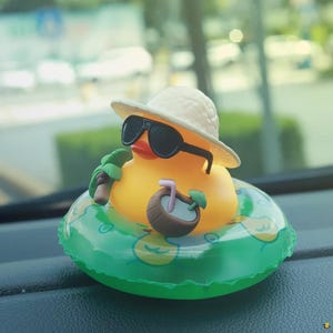 May include: A yellow rubber duck wearing sunglasses and a straw hat, floating on a green inflatable ring. The duck is holding a miniature coconut drink. A fun, summer-themed decorative item.