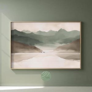 May include: A framed landscape art print depicting a tranquil mountain scene. The artwork shows layered mountains in green and brown hues, reflected in still water. The print is set in a gold frame, creating a calming aesthetic.