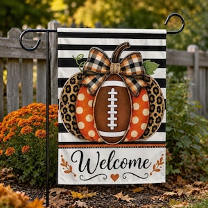 May include: A rectangular garden flag featuring a black and white horizontal striped background. The center displays a pumpkin with orange polka dots, leopard print sections, and a football-shaped core, topped with a plaid bow. The word Welcome is printed below.