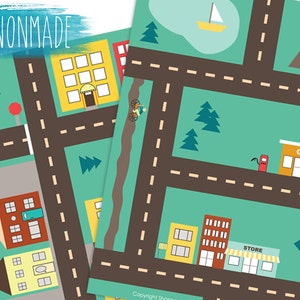 May include: A printable play mat for children featuring a city scene with roads, buildings, trees, and a petrol station. The mat is printed on white paper with brown, yellow, red, and green colours.