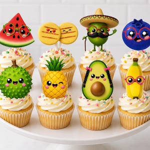 Op de afbeelding: Een set van acht cupcakes met kleurrijke, cartoonachtige fruit- en voedseltoppers. De toppers bestaan uit een watermeloenpartje, twee koekjes, een limoen met een sombrero en snor, een bosbes, een durian, een ananas, een avocado en een banaan.