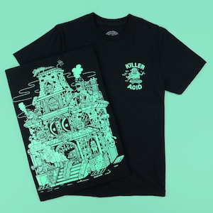 May include: Two black t-shirts. One shirt features a detailed, neon green illustration of a haunted house. The other shirt has the words "KILLER ACID" and a graphic on the front. Both shirts are made of a soft material.