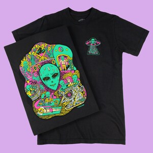 May include: Black t-shirt with a colorful graphic of an alien head and other alien figures. The design includes the text "NO BAD TRIPS" and a UFO. A matching print is displayed next to the shirt.