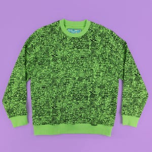 May include: A neon green sweatshirt with a black doodle pattern covering the entire garment. The crew neck, cuffs, and hem are a matching neon green. The sweatshirt has a relaxed fit and a tag with text on the inside of the collar.