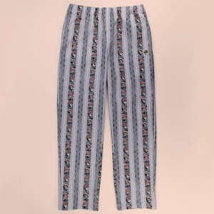 May include: Full-length trousers featuring a vertical striped pattern in shades of grey and blue. The design includes alternating bands of zigzag lines and a repeating print of small mushrooms. The pants have an elasticized waistband.