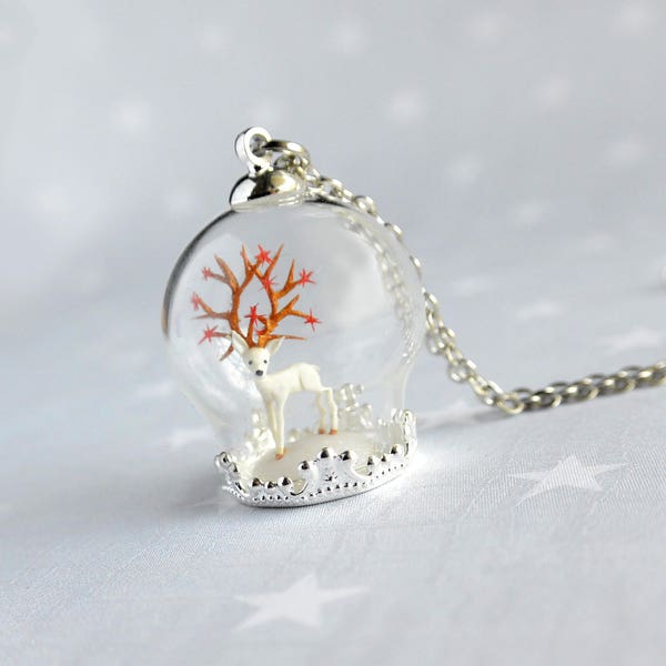 Collier terrarium cerf blanc sous une bulle de verre.