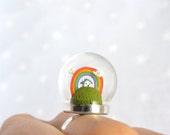 Bague terrarium miniature. Petite Maison avec arc-en-ciel et nuages sous une bulle de verre.