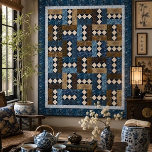 May include: A rectangular wall quilt featuring a geometric pattern of interlocking blocks in shades of navy blue, brown, and cream. The quilt has a wide dark blue border with a subtle leaf print and a thin light blue inner frame.