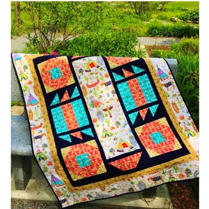 May include: A colorful quilt pattern called "Tee Pee Town" made with fabrics from the "Pow Wow" collection by Exclusively Quilters. The quilt features a variety of geometric shapes and designs in shades of red, orange, yellow, blue, green, and black.