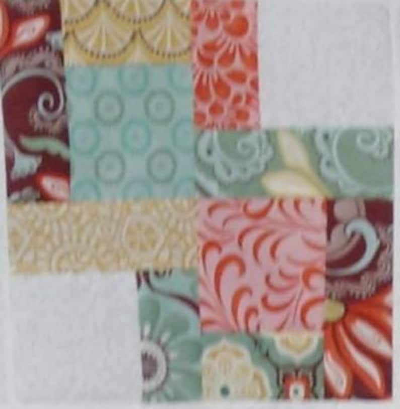May include: A patchwork quilt block with a variety of floral patterns in shades of pink, red, green, and yellow. The block is made up of nine smaller squares, each with a different pattern.