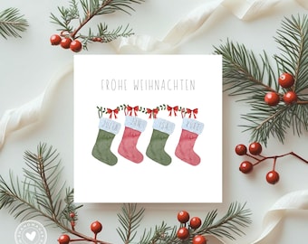 May include: A square Christmas card with the words "Frohe Weihnachten" above four stockings. The stockings are green and pink with white cuffs, each bearing a name. The card is surrounded by greenery, red berries, and white ribbon.