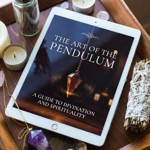 May include: A wooden tray holds a tablet displaying "The Art of the Pendulum: A Guide to Divination and Spirituality." Accompanying items include candles, crystals, a bundle of sage, and a small vase of lavender, suggesting a spiritual theme.