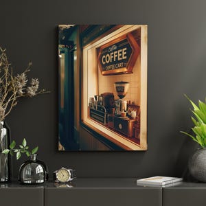May include: A framed print of a coffee shop interior. The sign reads "Coffee Coffee Cart". A coffee grinder, espresso machine, and cups are visible. The color palette is warm, with browns and creams.