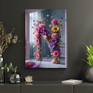 Pode incluir: Uma obra de arte emoldurada com a letra "N" formada por flores rosa, roxas e amarelas. O fundo é suave e desfocado, com um vislumbre de um quarto visível através de uma janela. A obra tem um tema floral delicado.