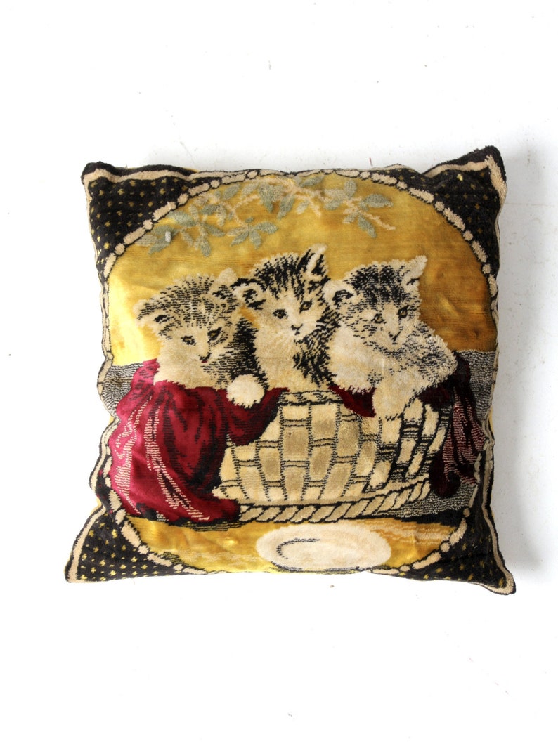 May include: A vintage velvet pillow with a gold background and a black border. Three kittens are depicted in a basket with a plate in front of them.