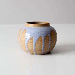 Könnte beinhalten: Eine kleine, runde Keramikvase mit hellbrauner Glasur und blauem Glasur, das an den Seiten heruntertropft.