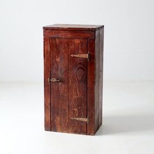 Peut inclure: Une armoire en bois brun foncé avec une seule porte et des charnières en laiton. L'armoire a un design simple et est en bon état.