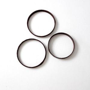 May include: Three brown wooden hoops of different sizes.