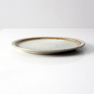 May include: A white ceramic plate with a brown rim. The plate has a slightly textured surface.