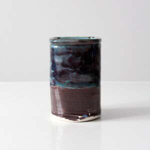 May include: A ceramic vase with a dark brown glaze and a blue and green glaze on the top half.