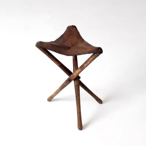 banquinho de viagem vintage de couro com três pernas