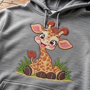 May include: A heather gray hooded sweatshirt featuring a large, colorful embroidered design of a cartoon giraffe sitting in green grass. The giraffe has brown spots, pink cheeks, and orange tufts of hair on its head and tail.