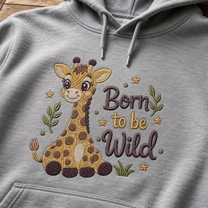 May include: A heather grey hooded sweatshirt featuring an embroidered design of a cartoon giraffe with brown spots. The text "Born to be Wild" is stitched in dark purple and gold thread, accompanied by small embroidered stars and green leaves.