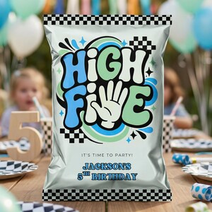 May include: A silver party favor bag with a black and white checkered top and bottom border. The bag features the words "HIGH FIVE" in blue, green, and white, with a hand graphic. Text at the bottom reads "JACKSON'S 5TH BIRTHDAY".