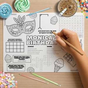 Könnte beinhalten: Eine weiße Papier-Tischunterlage mit dem Text "Monica's Birthday" und verschiedenen Aktivitäten, darunter ein Kreuzworträtsel und Ausfüllübungen. Eine Hand hält einen Bleistift und bearbeitet die Aufgaben. Cupcakes, Bleistifte und Konfetti sind verstreut.