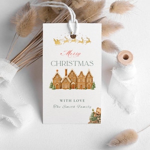 May include: A white Christmas gift tag featuring a gingerbread house illustration and the words "Merry Christmas". The tag also has a gold sleigh and reindeer design, and the text "With Love The Smith Family".