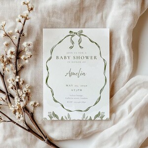 May include: A baby shower invitation with the text "Join us for a Baby Shower in Honor of Amelia." The invitation features a green floral wreath design and is dated May 25, 2030, at 7 PM.