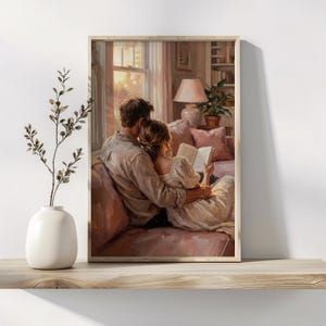 May include: A framed print showing a couple reading a book on a pink sofa. The man embraces the woman as they read together in a sunlit room. A lamp, potted plant, and bookshelf are visible in the background. The artwork is displayed on a wooden shelf.