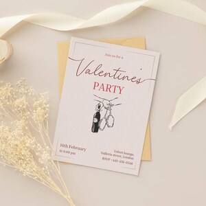 May include: A Valentine's Party invitation card with the words "Valentine's PARTY" in a stylish font. The invitation includes the date, time, and location. The card features a drawing of a wine bottle and glasses. The card is on a cream-colored background.