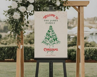 Puede incluir: Un letrero de bienvenida para una fiesta de Navidad, exhibido en un caballete negro. El letrero presenta el texto "Welcome to The James Family" en rojo, con un diseño de árbol de Navidad verde hecho de lazos. Las palabras "Christams party" también están en rojo.