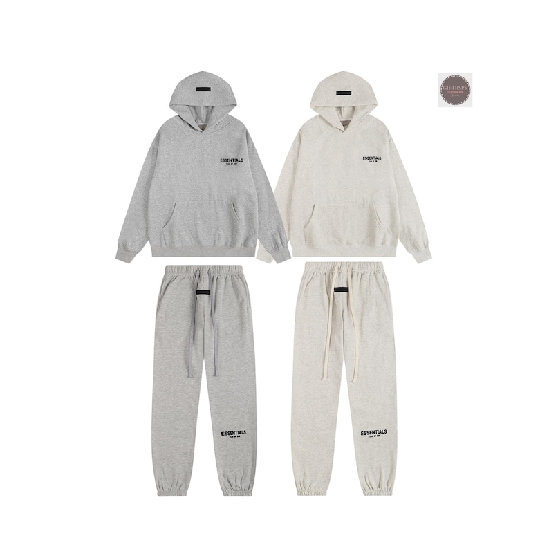 May include: Two matching gray and cream-colored hoodie and sweatpants sets. Each hoodie has a hood and a front pocket. The sweatpants have a drawstring and the word "ESSENTIALS" printed on the front.