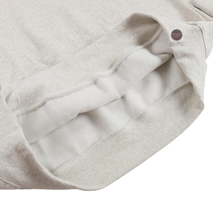 May include: Close-up of a light gray sweatshirt interior. The inside is lined with a soft, white material. The ribbed cuffs and collar are visible, with a small button detail near the collar.