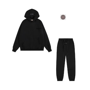 K&ouml;nnte beinhalten: Schwarzes Hoodie- und Jogginghosen-Set. Das Hoodie hat eine Vordertasche und eine Kapuze. Die Jogginghose hat einen Kordelzug in der Taille und elastische B&uuml;ndchen. Das Set ist aus weichem Material.
