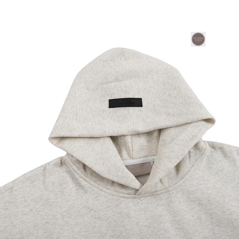 May include: A light gray hoodie with a drawstring neckline and a hood. A small black rectangular label is sewn on the hood. The hoodie is made of a soft, textured material.