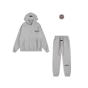 May include: A gray hoodie and matching sweatpants set. The hoodie has a front pocket and the word "ESSENTIALS" printed on the chest. The sweatpants have a drawstring waist and the word "ESSENTIALS" printed on the lower left leg.