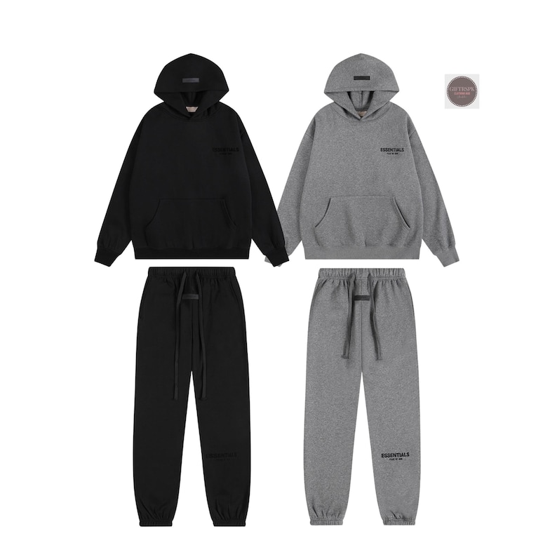 K&ouml;nnte beinhalten: Zwei passende Sets aus Kapuzenpullovern und Jogginghosen. Ein Set ist schwarz, das andere grau. Jedes Set enth&auml;lt einen Hoodie mit Fronttasche und Jogginghose mit Kordelzug. Der Markenname "Essentials" ist auf Brust und Bein aufgedruckt.