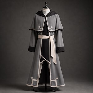 May include: A floor-length gray hooded robe featuring a black hood lining, black sleeve cuffs, and a black central panel. The garment includes a cream-colored waist sash and white geometric square accents along the hem and shoulder cape edges.