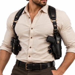 Könnte beinhalten: Ein Schulterholster-System aus schwarzem Leder mit einer Waffenholster-Seite und einer doppelten Magazintasche auf der anderen Seite. Das System verfügt über verstellbare Riemen, messingfarbene Metallbeschläge und sichere Druckknopfverschlüsse.