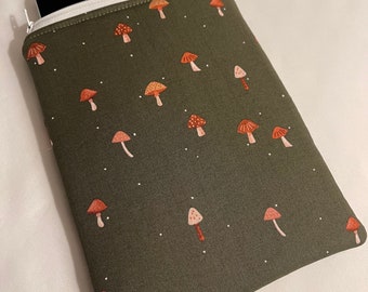 Puede incluir: Una bolsa verde con cremallera con una cremallera blanca y un patrón de setas. Las setas son rojas y blancas.